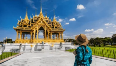 Traveler admiring a golden temple in Bangkok, Thailand