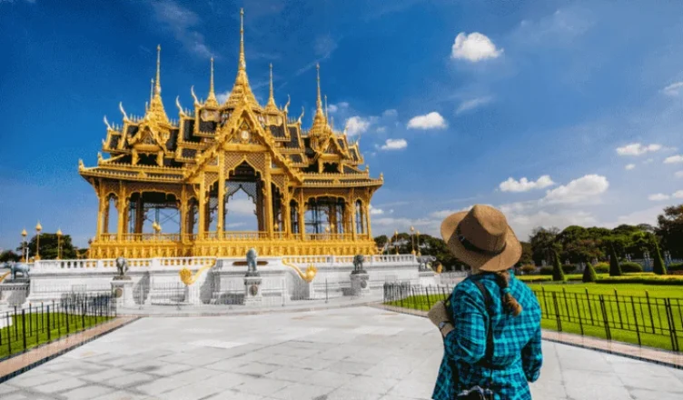 Traveler admiring a golden temple in Bangkok, Thailand