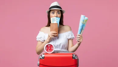Young woman holding travel tickets and a map
