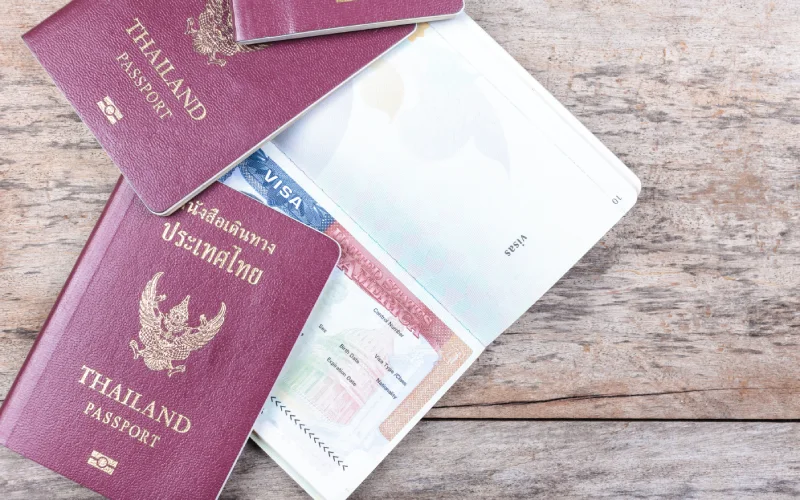 Thai passports and visa on a wooden surface