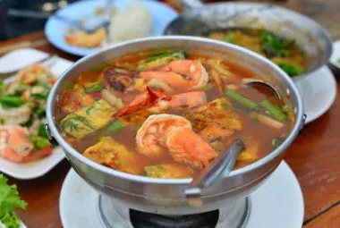 Spicy and sour Thai Tom Yum Goong soup with shrimp and herbs
